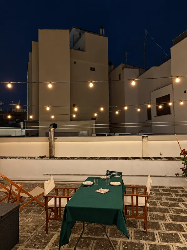 Rooftop terrace of BDS House at night with string lights, Brindisi old town
